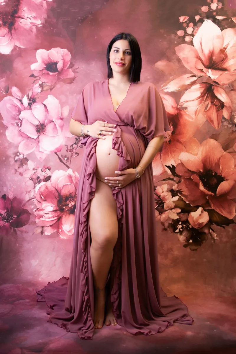 Donna incinta in abito rosa su fondo a fiori