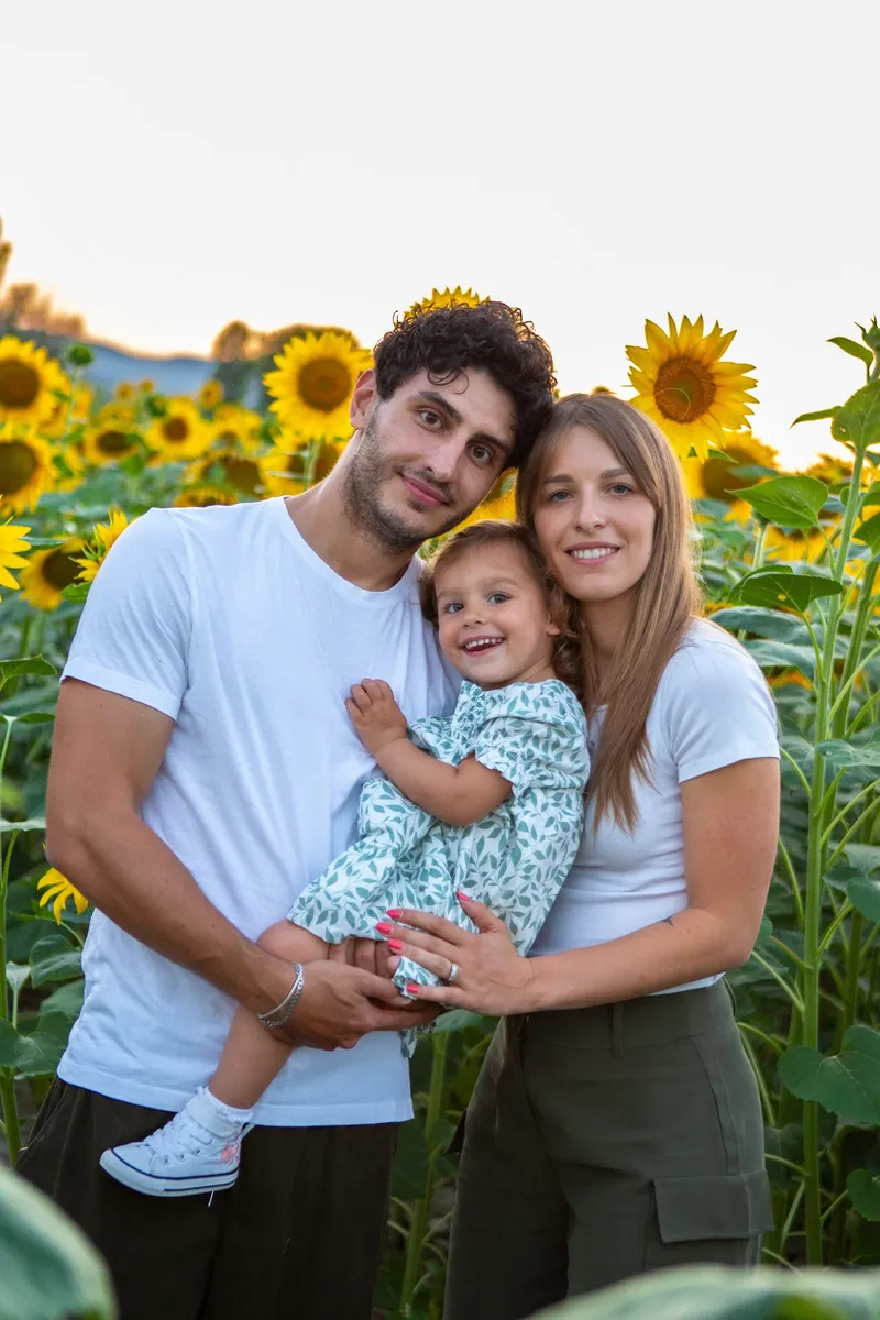 Famiglia con bambina fra i girasoli