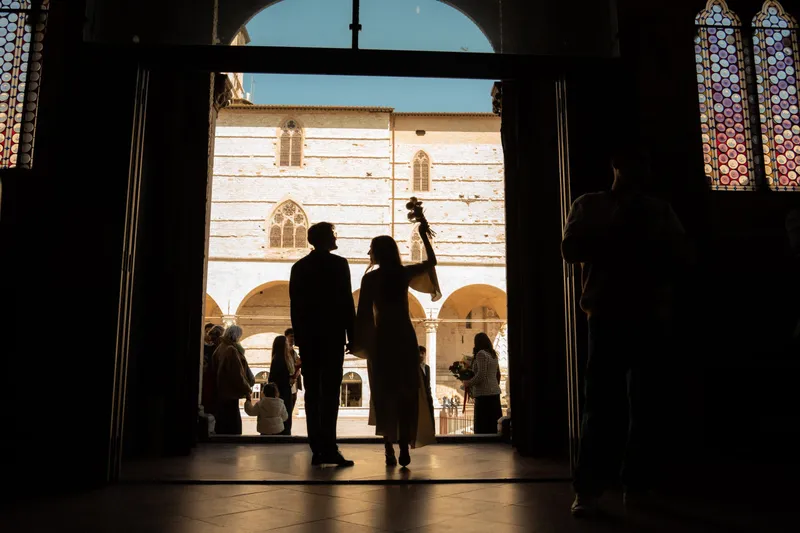 Sposi in controluce sulla porta di una chiesa