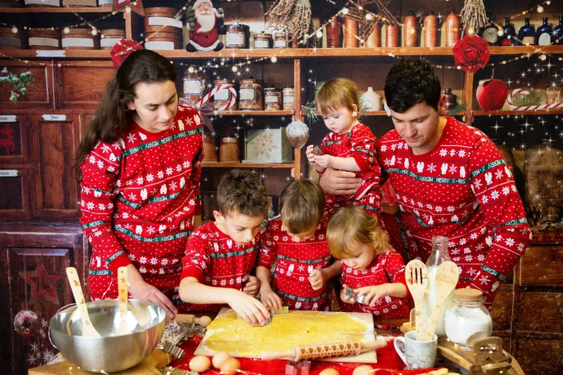 Famiglia in maglioni rossi che impasta i biscotti