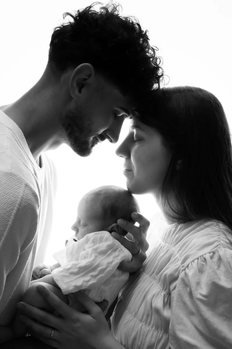 Genitori con il neonato in controluce