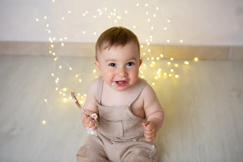 Bambino sorridente fra le lucine dorate