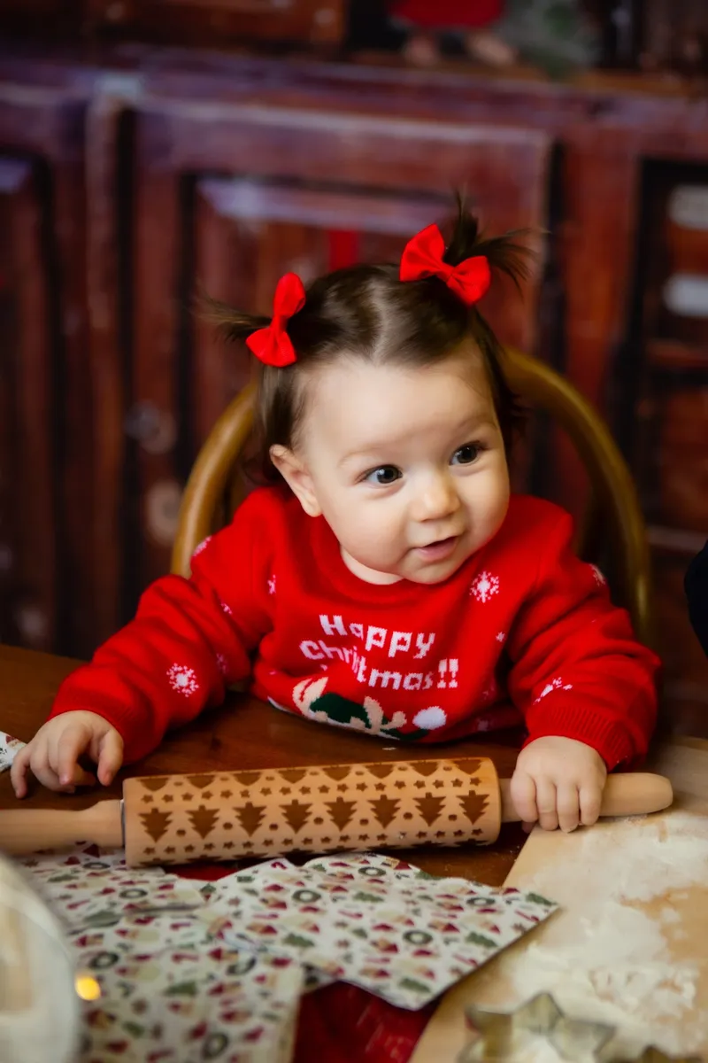 Bambina con fiocchi rossi e mattarello
