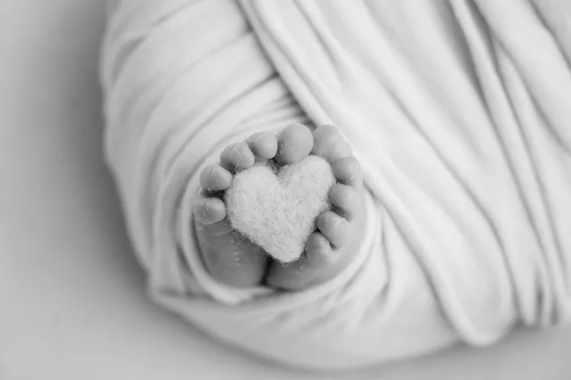 Piedini di neonato con un cuore di lana