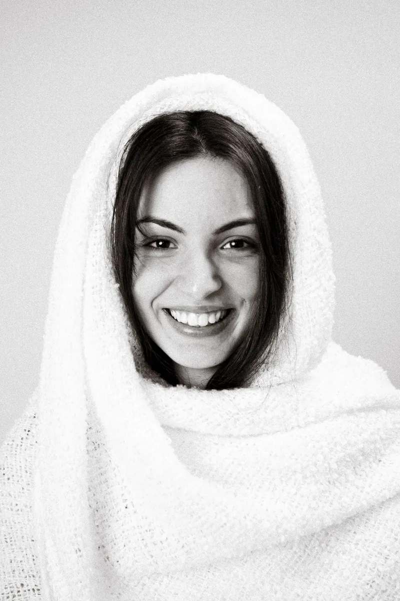 Ragazza sorridente con uno scialle bianco