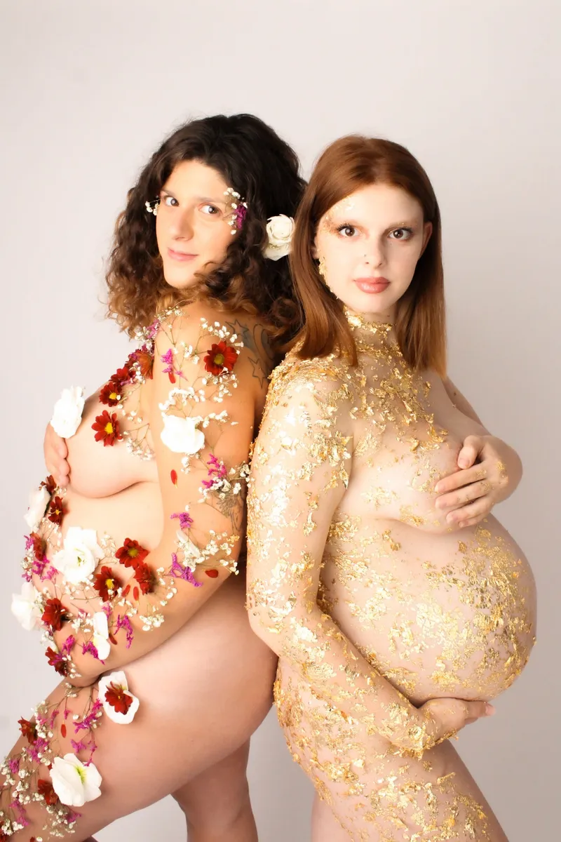 Due donne incinte schiena contro schiena con fiori e oro