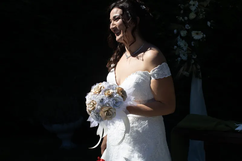 Sposa sorridente con un bouquet di carta