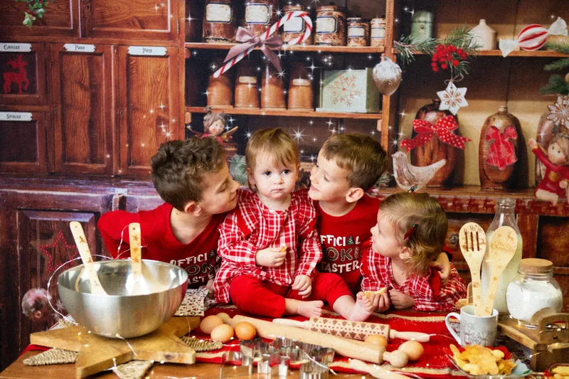Quattro bambini in pigiama in una cucina natalizia