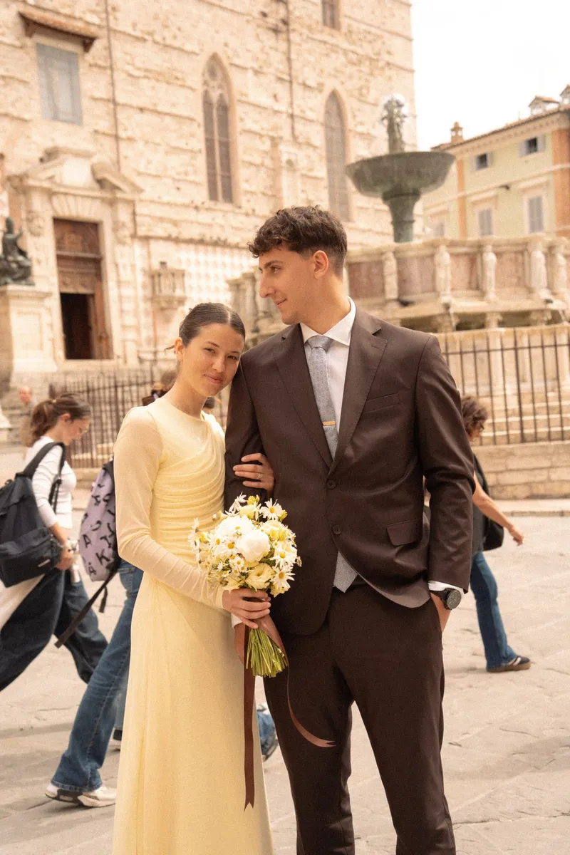 Sposi con il bouquet in una piazza