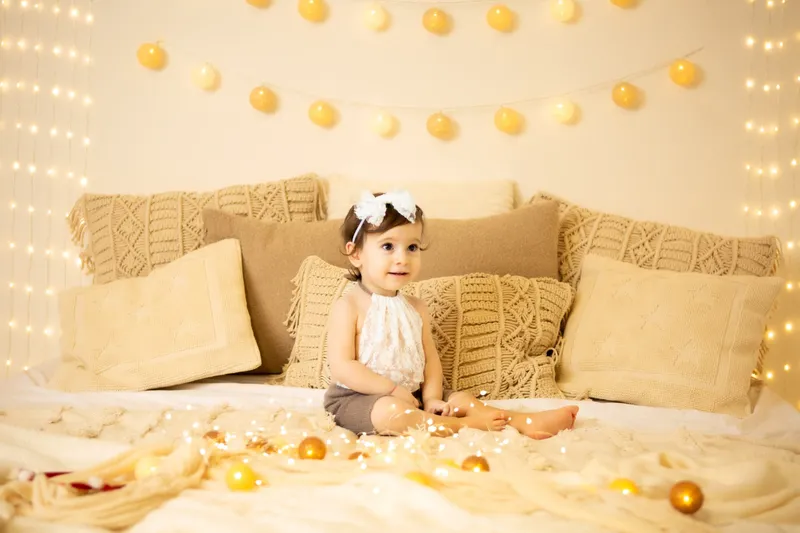 Bambina seduta sul letto fra le lucine