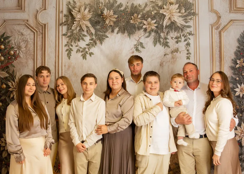 Famiglia numerosa davanti a un fondale natalizio