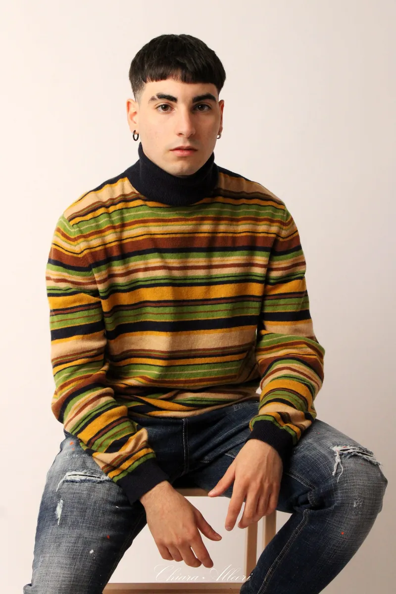 Ragazzo seduto con maglione a righe
