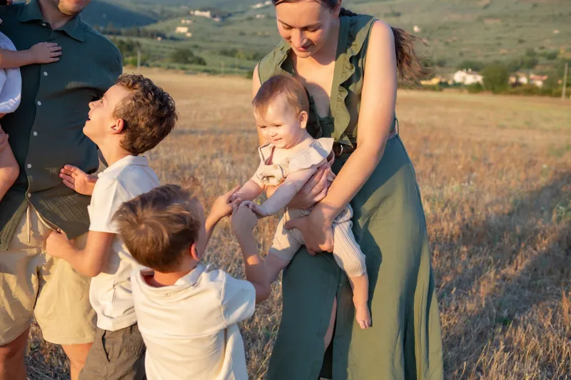 Mamma con tre bambini in un campo al tramonto