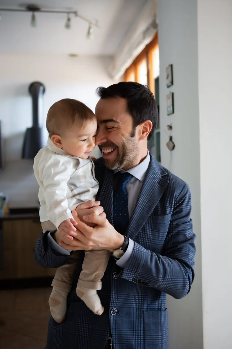 Uomo sorridente con un bambino in braccio