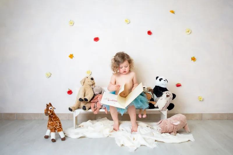 Bambina che legge fra i peluche