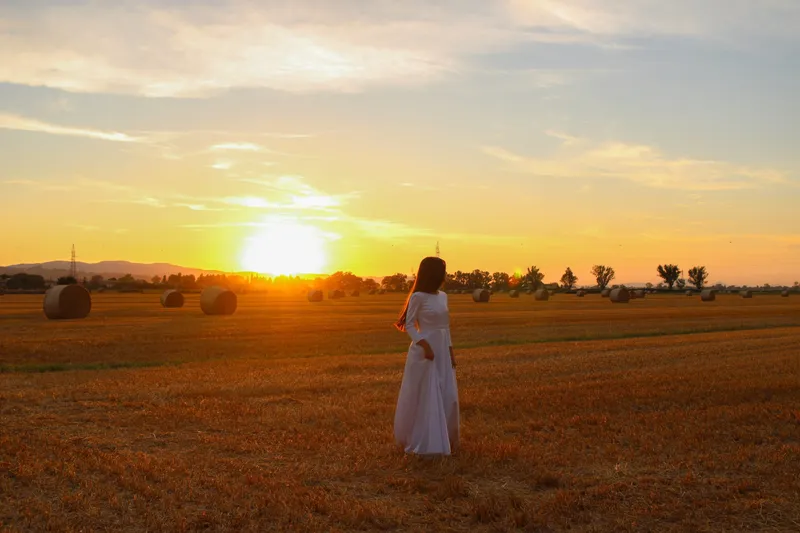 Donna in un campo al tramonto