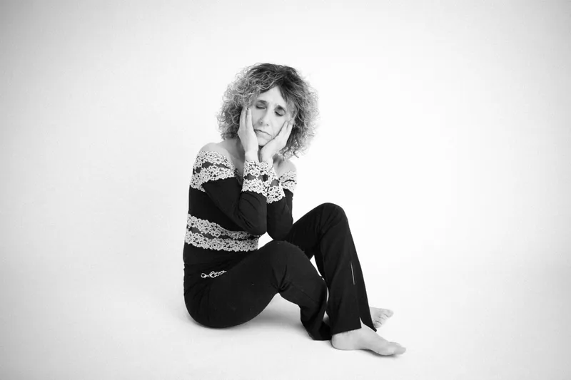 Donna dai capelli ricci seduta in studio