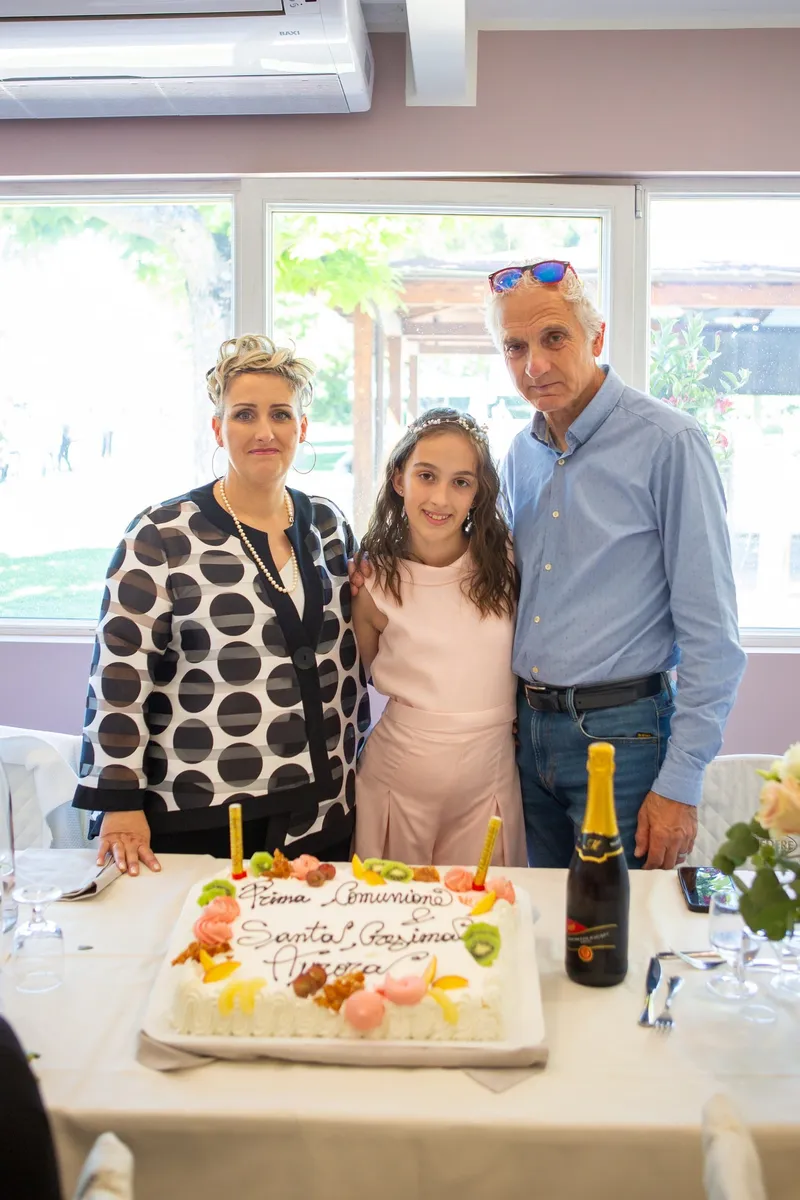 Famiglia davanti alla torta di una festa